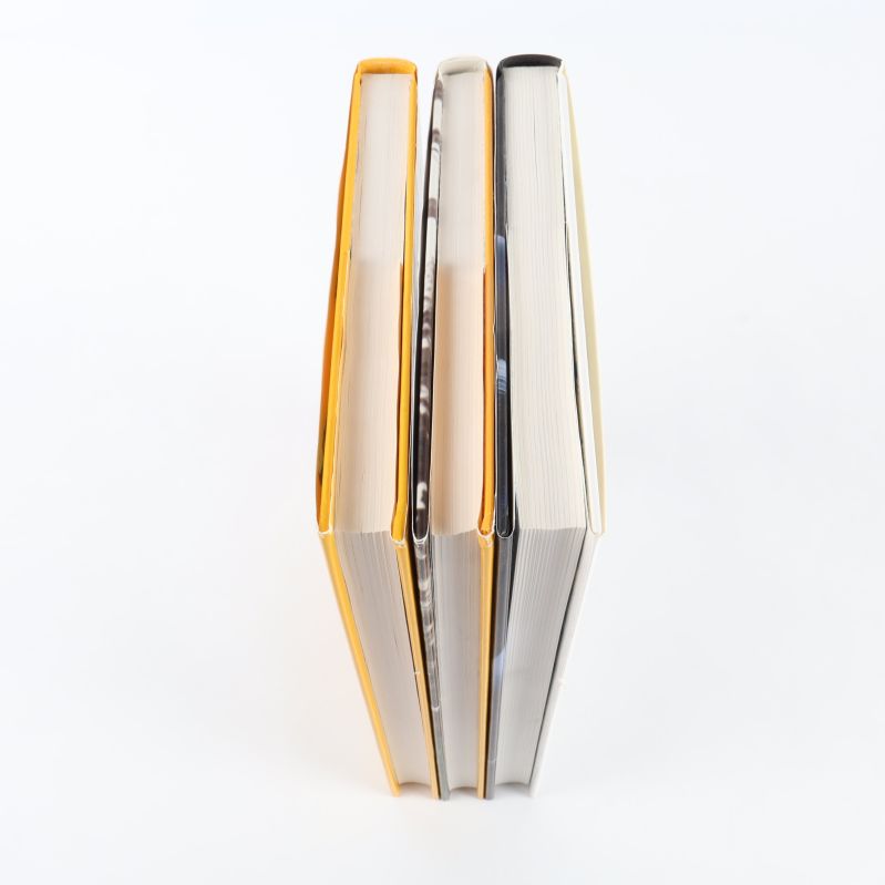 Överblick av tre böcker stående, med olika tjocklek och färg