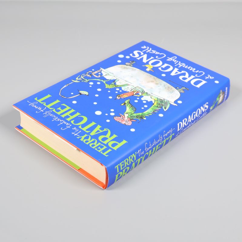 Drakbok Dragons at Crumbling Castle liggande med synligt tjockt bokblock