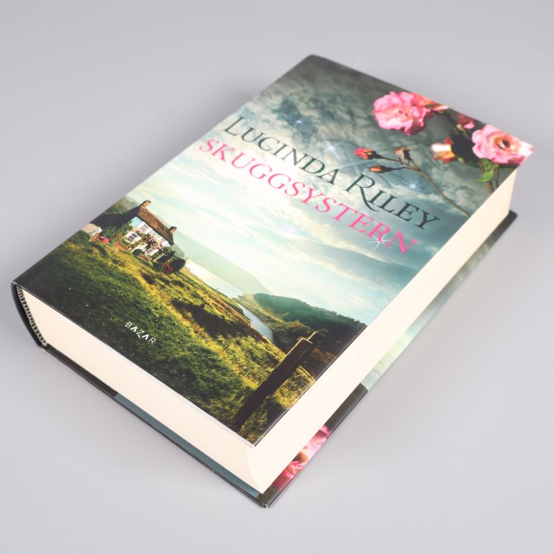 Skuggsystern del 3 av Lucinda Riley, halvöppen bok med omslaget synligt