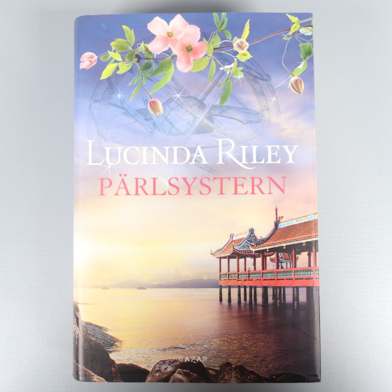 Framsidan av boken Pärlsystern med färgstarkt tempel och blomsterdetaljer