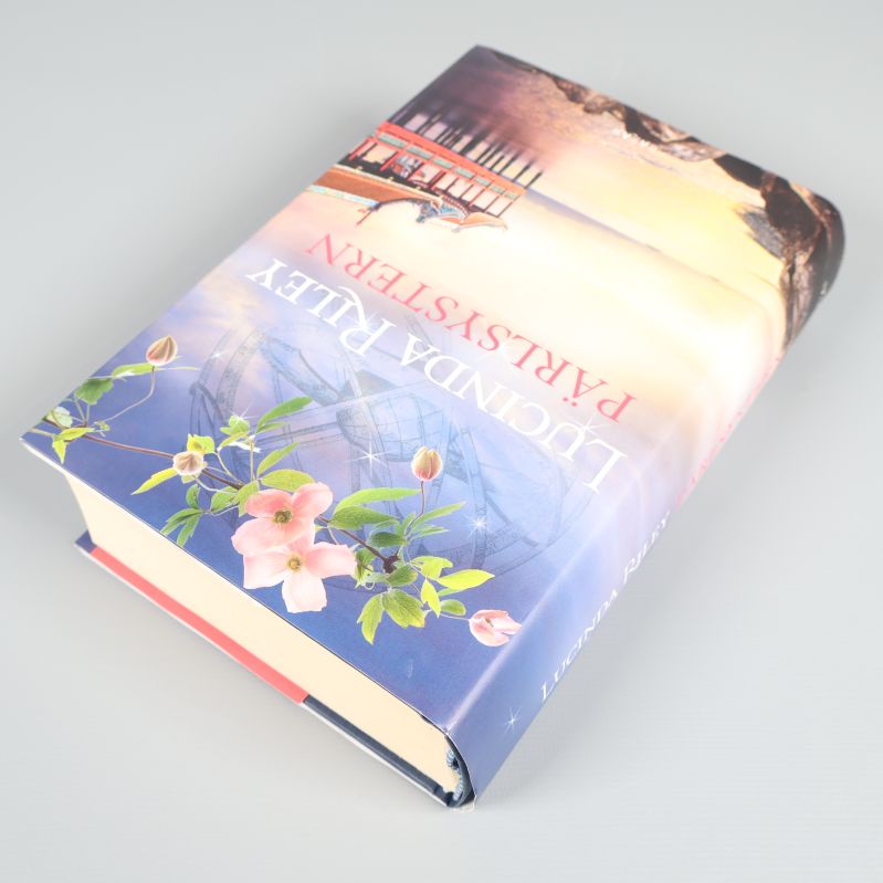 Boken Pärlsystern placerad snett med omslaget synligt och blommotiv