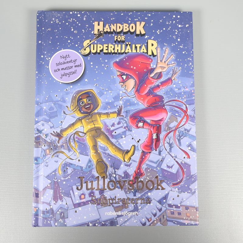 Framsida av Handbok för superhjältar jullovsbok Snöpiraterna, med två barn i vinterstad