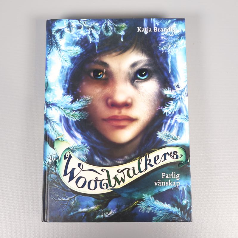 Framsida av boken Woodwalkers Farlig vänskap med färgstarkt omslag och ansikte i närbild