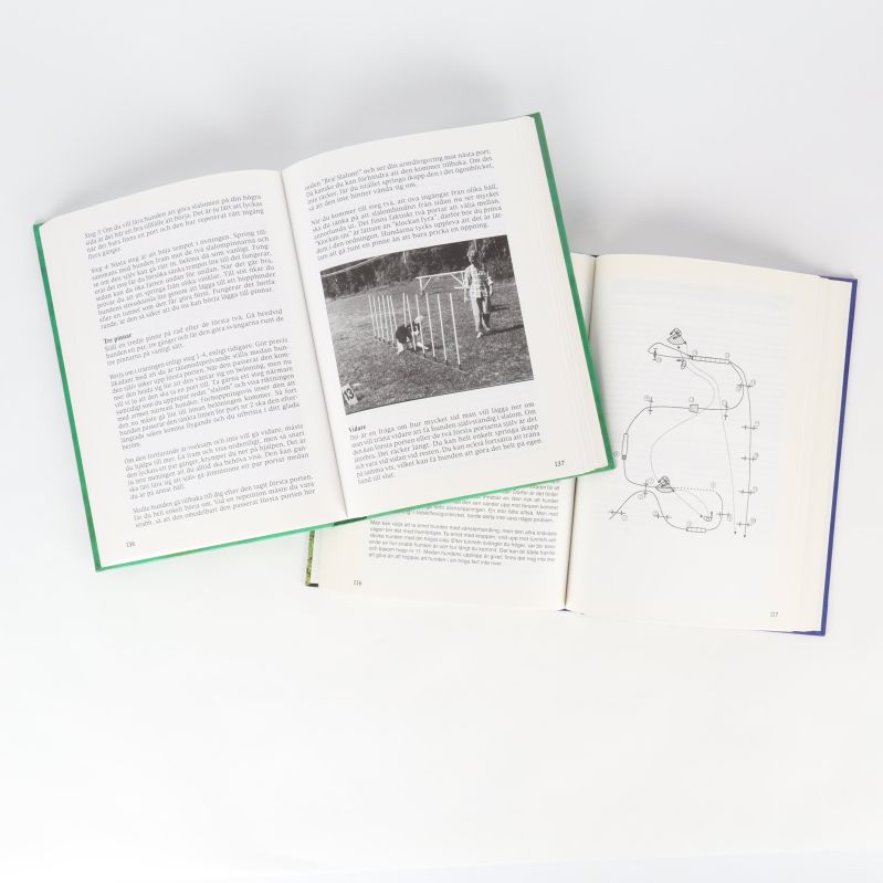 Uppslagna agilityböcker med instruktionstexter, skisser och foton