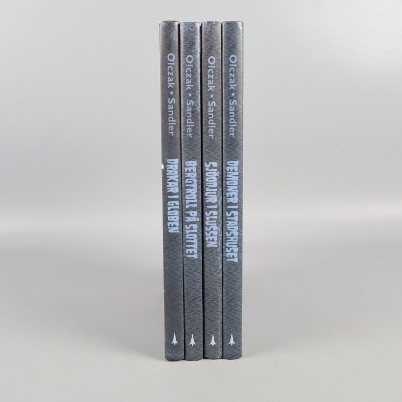 Ryggen på fyra böcker med titlar och författare