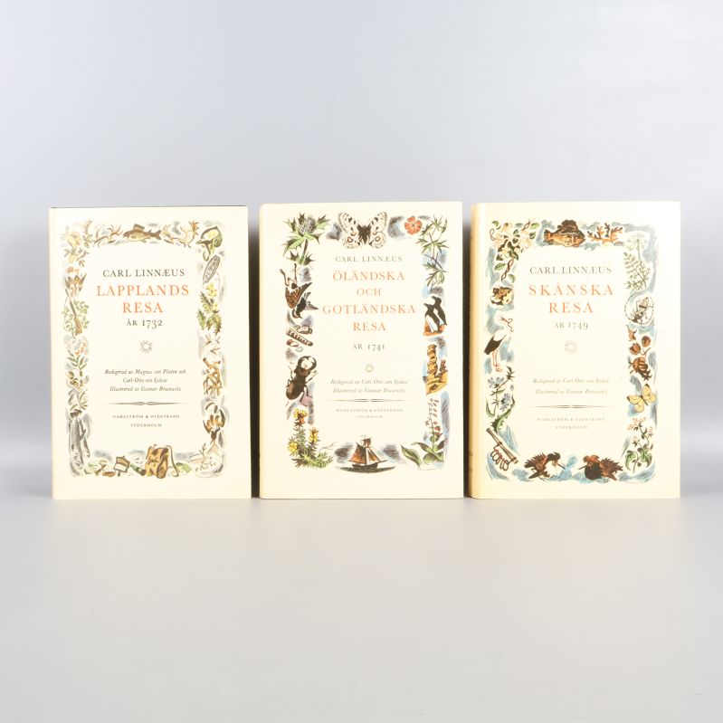 Tre böcker av Carl Linnaeus med färgstarka omslag och titlar synliga