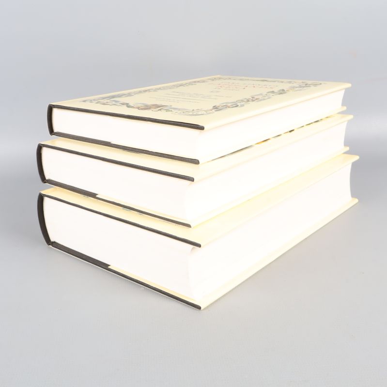 Tre böcker staplade med synliga bokryggar och sidor