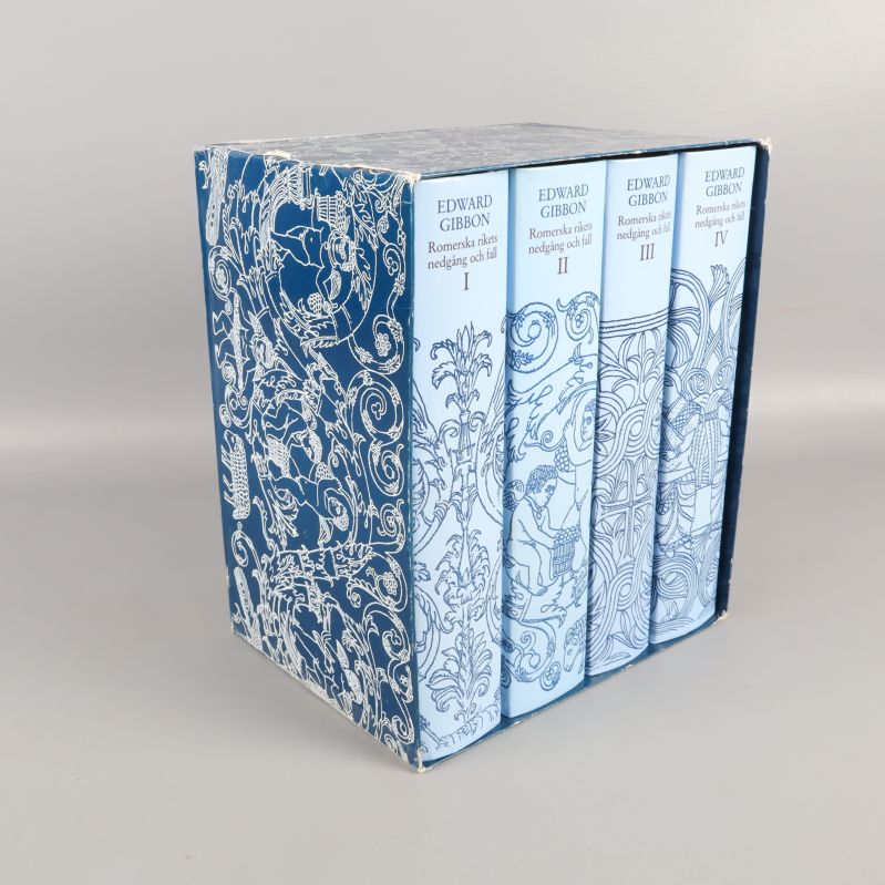 Fyra böcker i box med blåvitt mönster och titlar på ryggen