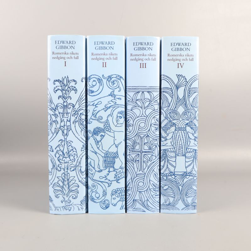 Fyra bokryggar med titlar och blåvit dekor