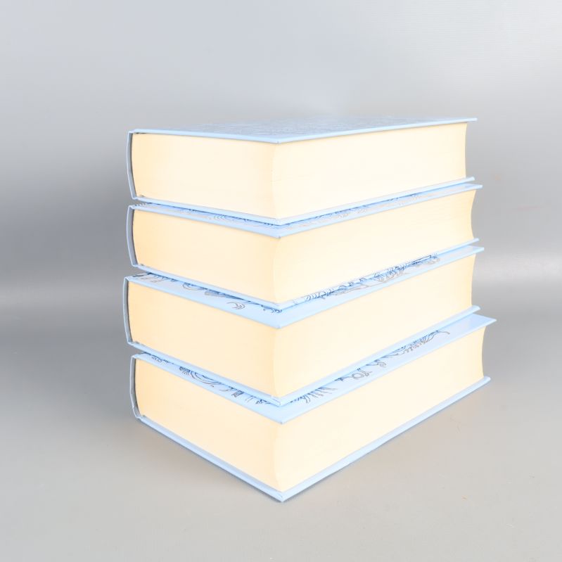 Böcker staplade med synliga sidor och blåvita pärmar