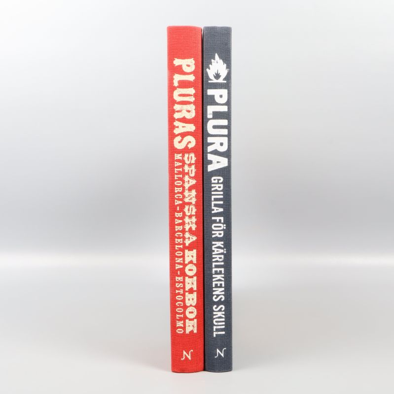 Ryggen på två kokböcker med tydliga titlar i vitt tryck