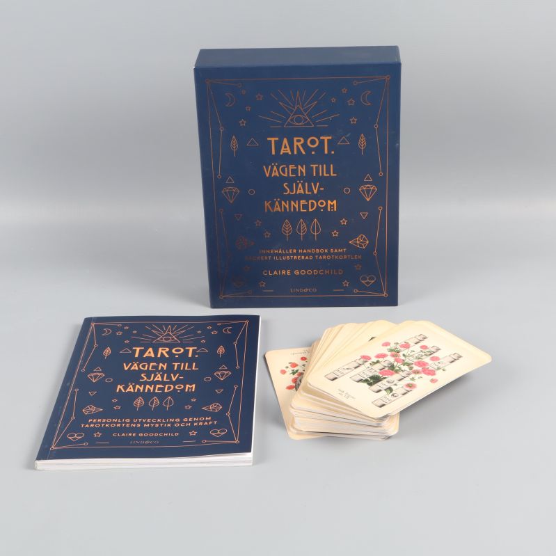 Tarotset med blå box, handbok och kortlek med blommotiv