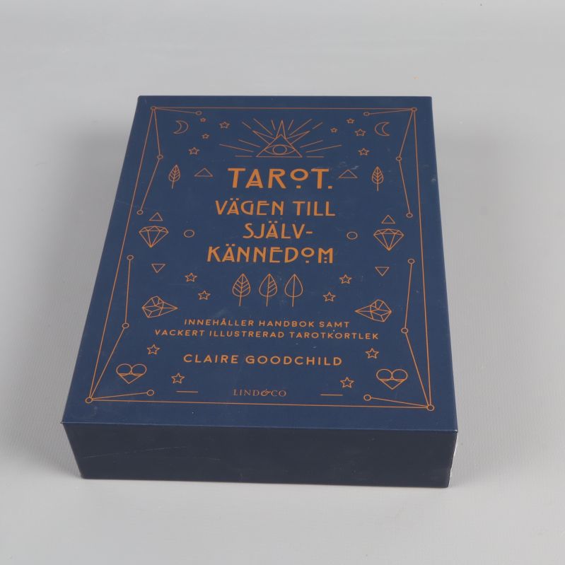 Stängd mörkblå tarotbox med guldfärgad dekor