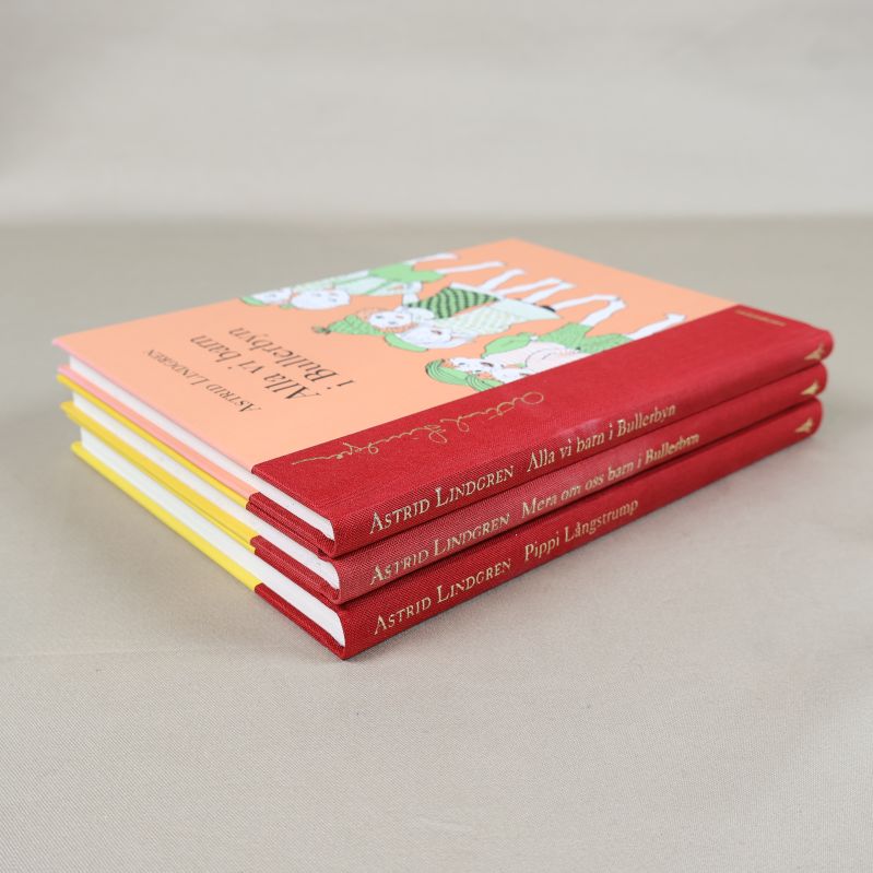 Snett staplade böcker av Astrid Lindgren med röda ryggar synliga