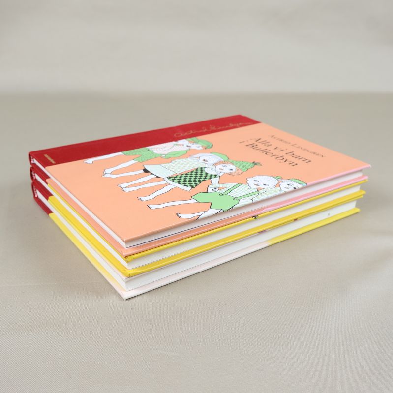 Tre barnböcker staplade diagonalt med olika färgade omslag