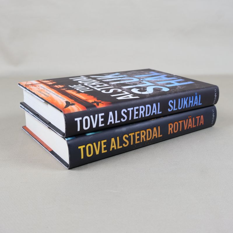 Böckerna Rotvälta och Slukhål staplade, sedd från sidan