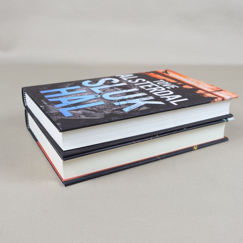 Böckerna Slukhål och Rotvälta liggande på varandra, fokus på tjocklek