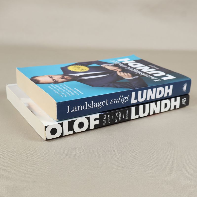 Två böcker liggande snett på varandra, visar rygg och tjocklek