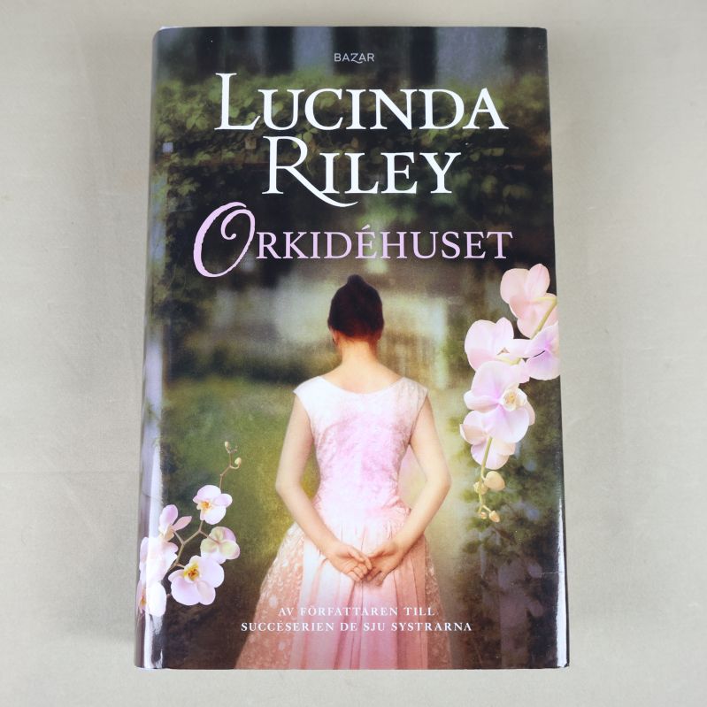 Framsidan av Orkidéhuset med blommor och person i rosa klänning