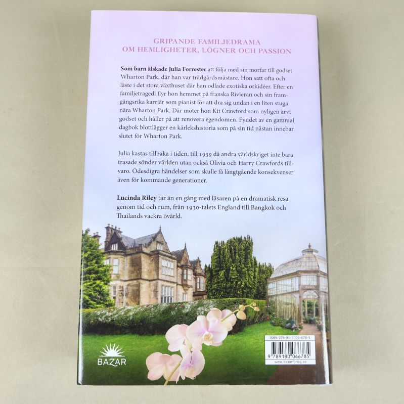 Baksidan av Orkidéhuset med beskrivande text och orkidémotiv