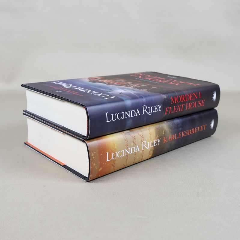 Två staplade böcker av Lucinda Riley fotograferade från sidan