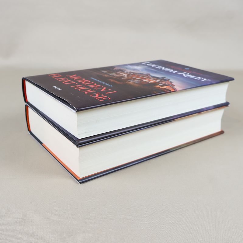 Två inbundna böcker staplade med fokus på sidorna