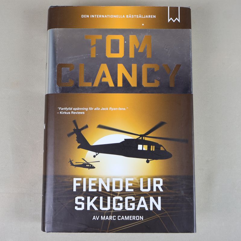 Framsida av Tom Clancy – Fiende ur skuggan med helikoptrar mot guldfärgad bakgrund