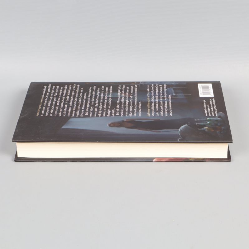 Boken sedd snett uppifrån med synlig pärm och sidor