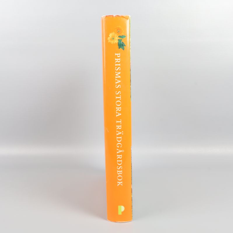 Bokrygg med texten Prismas stora trädgårdsbok mot orange bakgrund