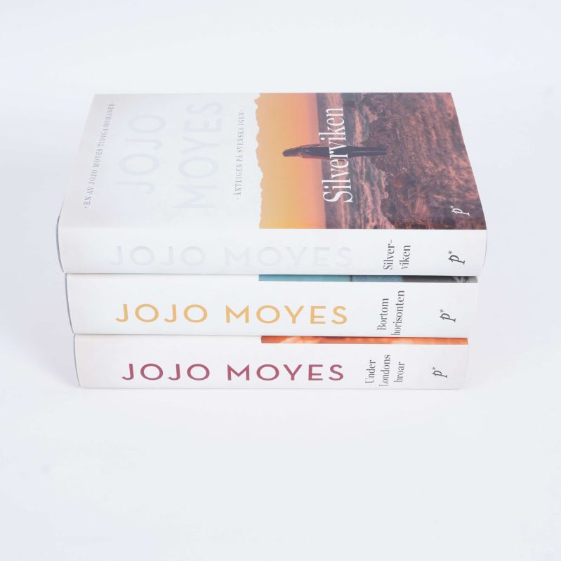 Tre böcker av Jojo Moyes staplade med synliga ryggar