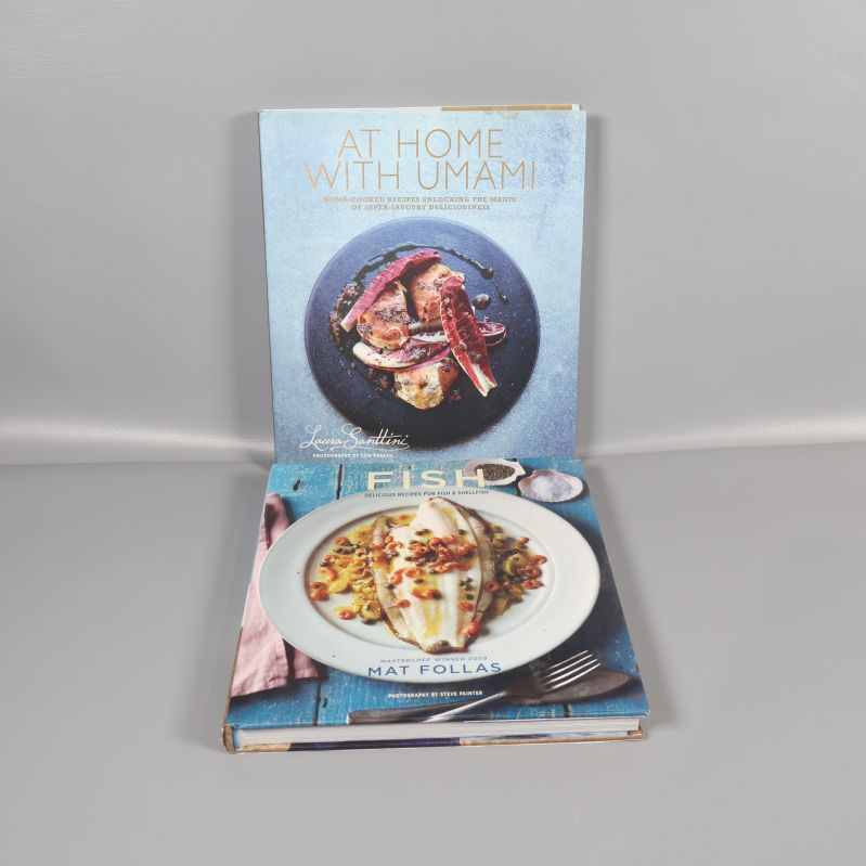 Två kokböcker: At Home With Umami och Fish, framsida med foton på rätter