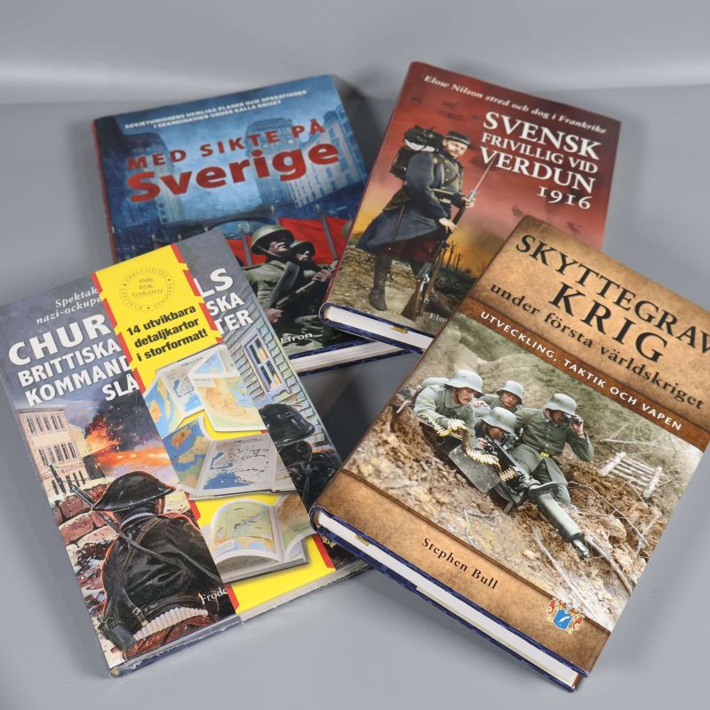 Fyra militärhistoriska böcker med tematiska omslag liggande på rad