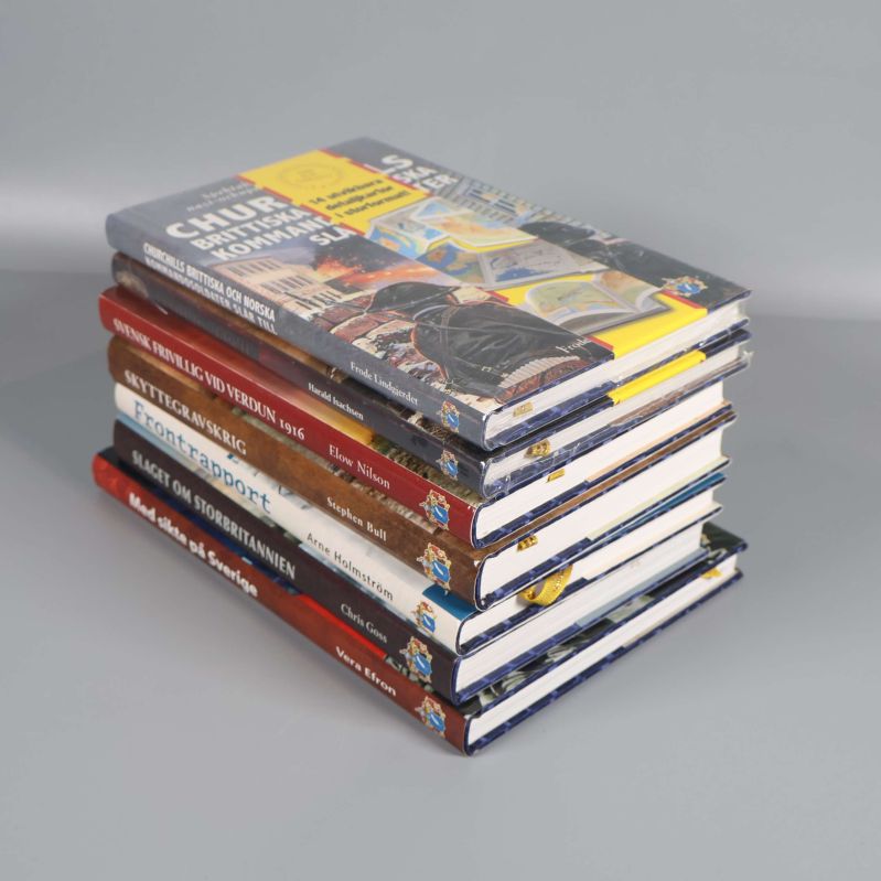 Sju militärhistoriska böcker staplade på hög med synliga ryggar