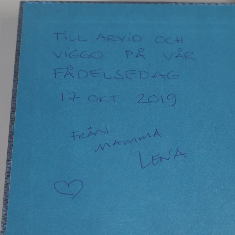 Handskriven hälsning på blått försättsblad i boken