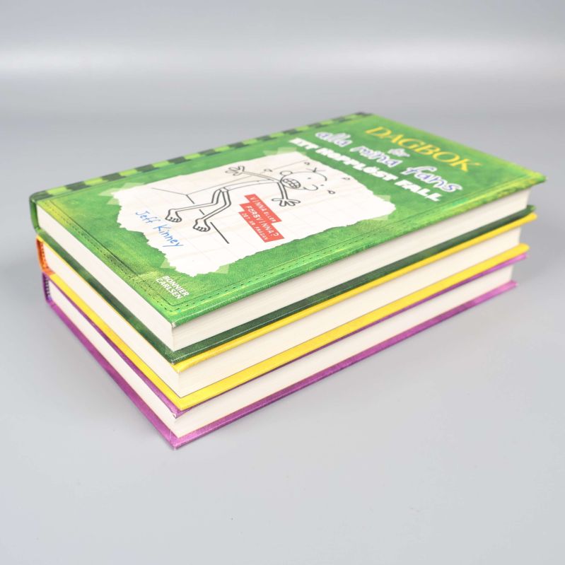 Böcker staplade snett med grönt omslag överst