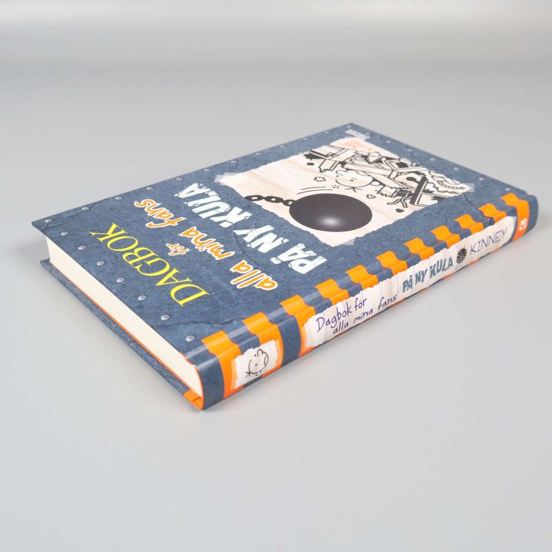 Boken ligger platt, framsidan och ryggen syns