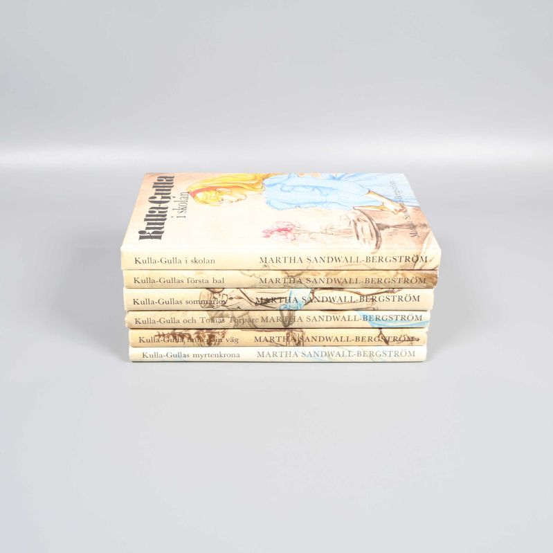 Kulla-Gulla-böcker staplade i profil med synliga ryggar