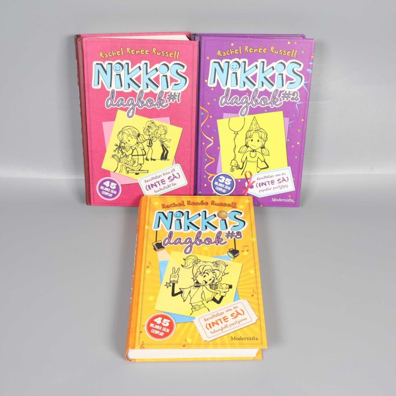 Framsidor på Nikkis dagbok 1, 2 och 3 i olika färger med tecknade illustrationer