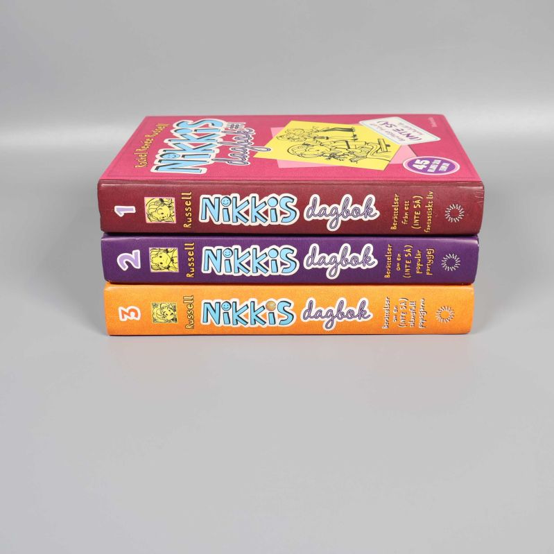 Ryggen på Nikkis dagbok 1, 2 och 3 staplade på varandra med tydliga titelnummer