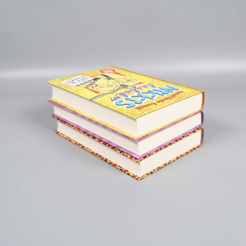 Tre böcker staplade på varandra med Nikkis dagbok #7 överst