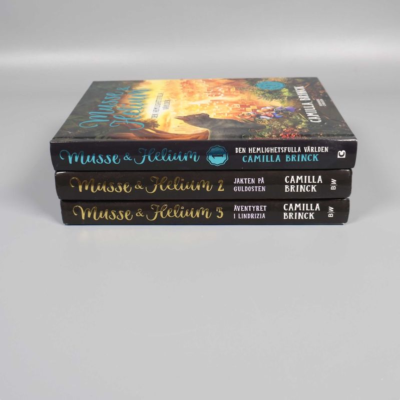 Tre Musse & Helium böcker staplade med ryggarna synliga