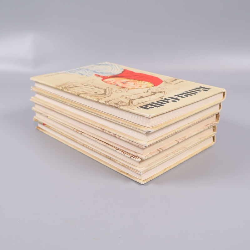 Fem Kulla-Gulla-böcker staplade från sidan på grå bakgrund