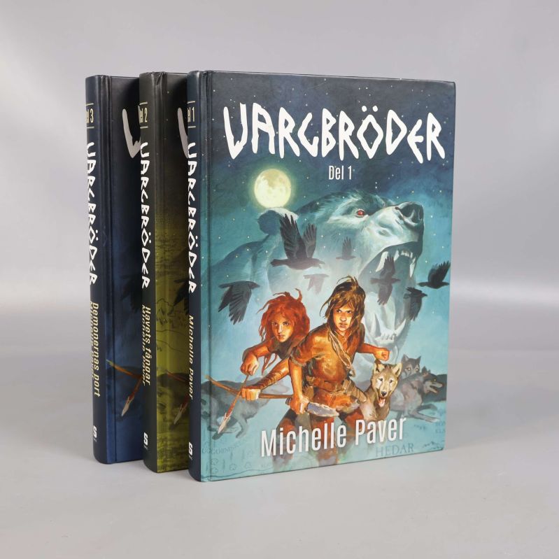 Tre böcker i serien Vargbröder stående med färgade omslag