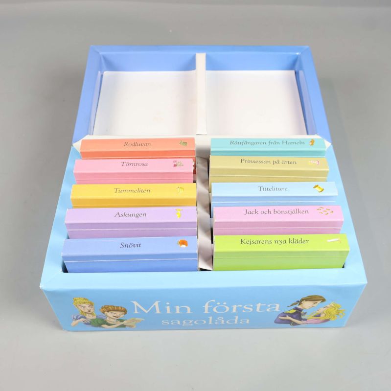 Öppen sagolåda visar tio små böcker i olika färger