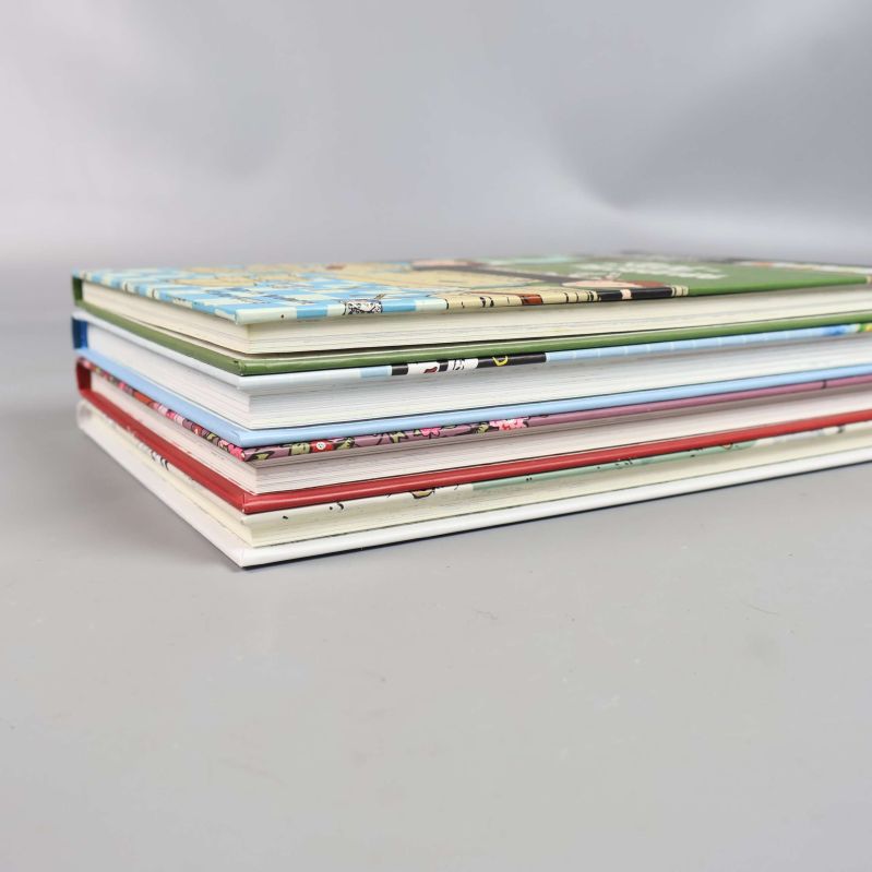 Staplade böcker från sidan med synliga omslag och sidor