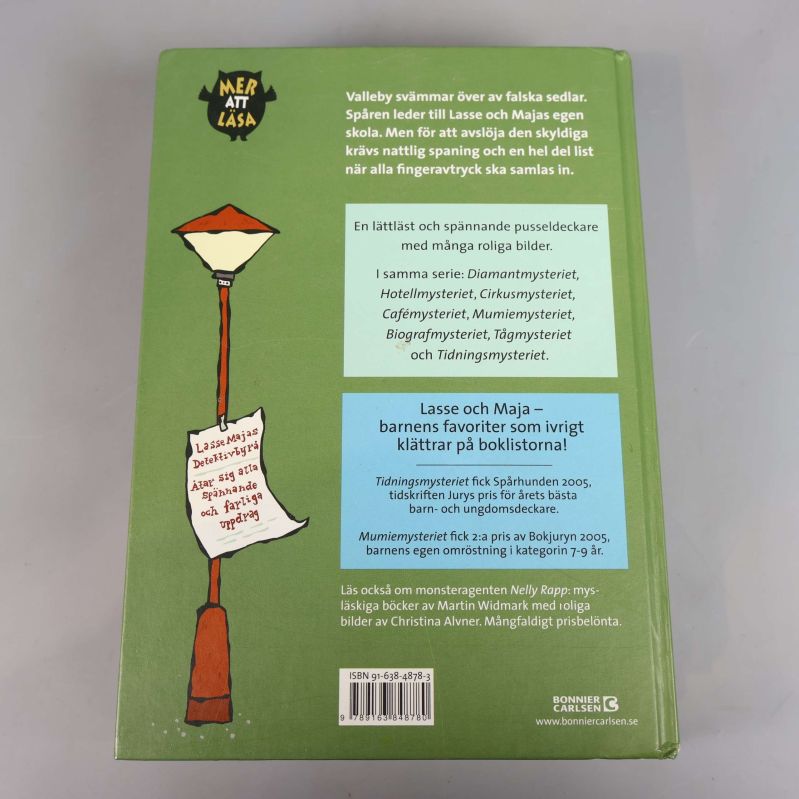 Baksida på Skolmysteriet med beskrivning och ISBN-nummer