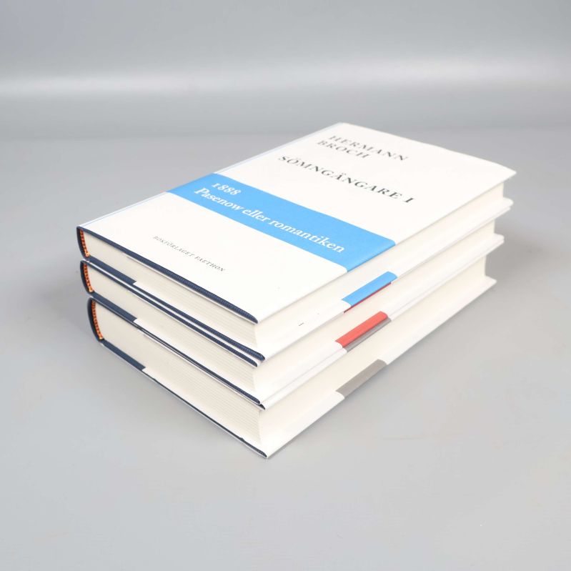 Sömn­gångare I ligger överst i bokstapel, tydlig markering med blått band