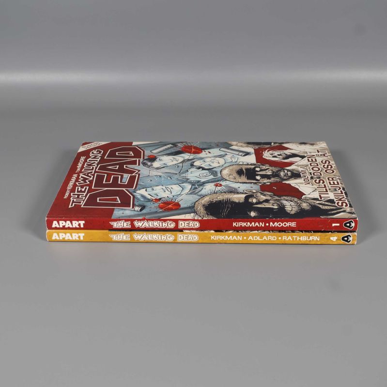 Ryggar av två The Walking Dead serieböcker placerade staplade