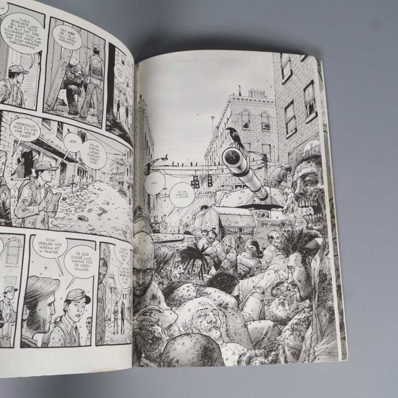 Uppslag med svartvita serierutor från The Walking Dead med zombietema