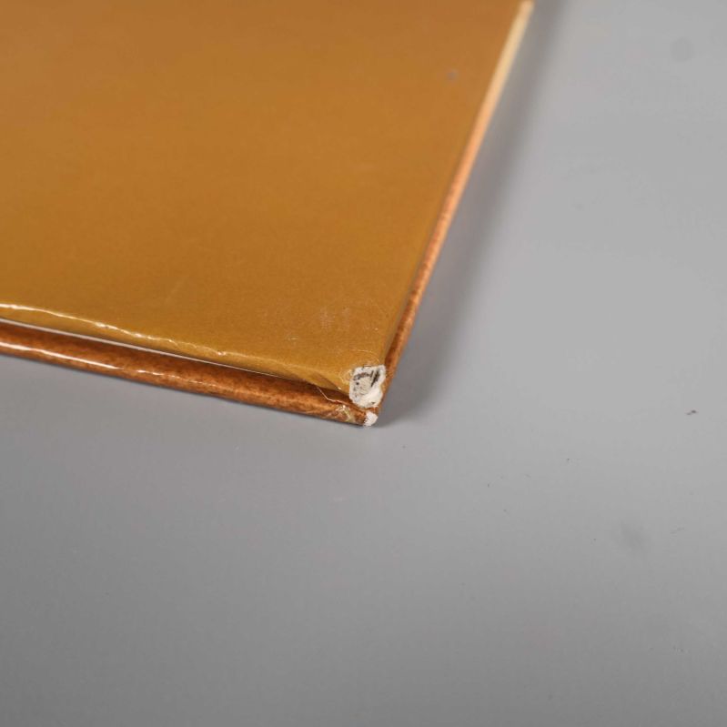 Detalj av guldfärgat bokhörn med tydliga skador